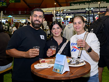 Three adults enjoy drinks at Woolworths Fresh Food Dome during the Sydney Royal Easter Show.